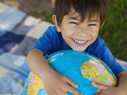 Smiling boy holding world map