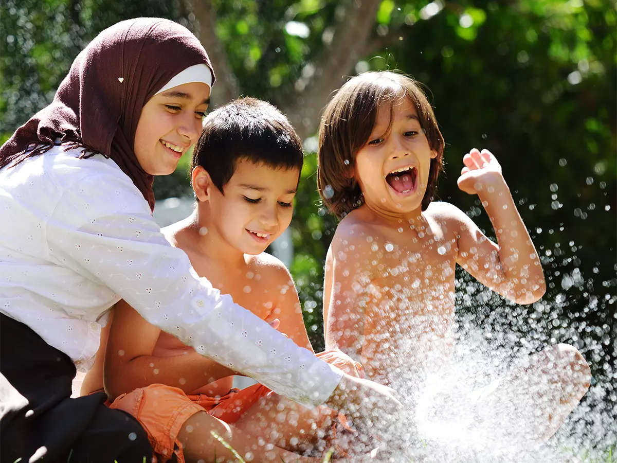 Kids playing in water sprinkler